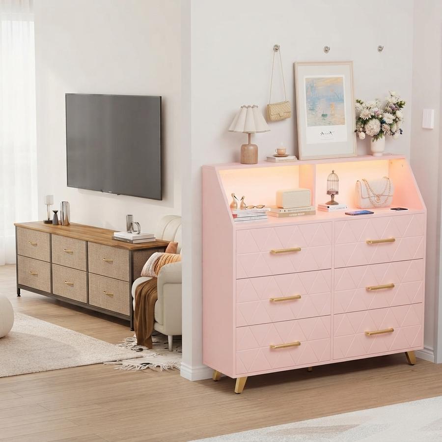 Six-drawer LED dresser with gold legs and a phone charging on top